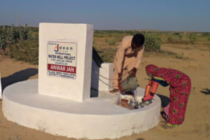 Picture of a family using the water wells installed by Deen Trust International.